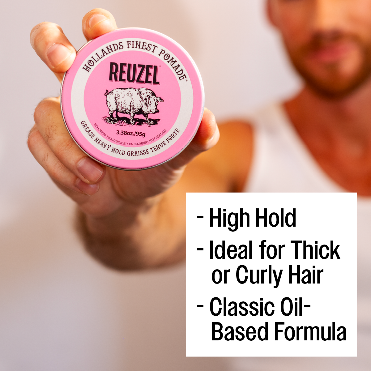Reuzel Pink Pomade Grease jar with pink lid and label, showcasing a shiny black container of pomade for styling hair.