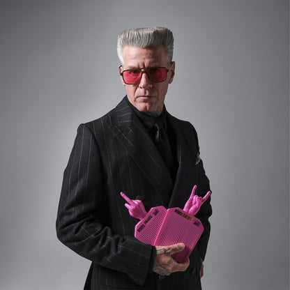 Man in a suit holding a pink object with antler-like features against a gray background